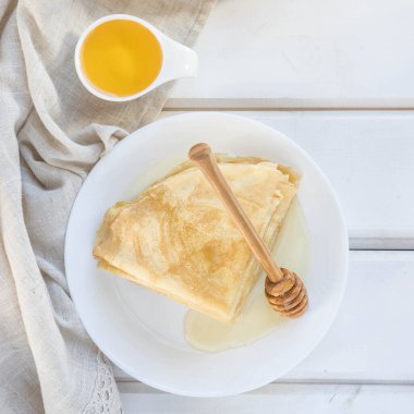 Beyaz tabakta krep. Beyaz ahşap bir masada krep. Rus gözlemesi üst görünüm . 