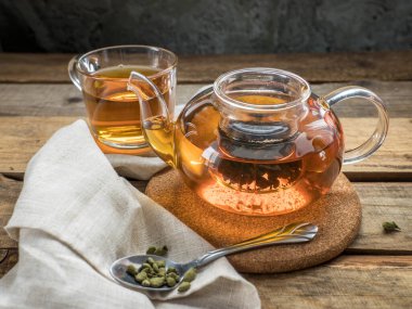 Çaydanlıkta Ginseng çayı. Ginseng Oolong çayı çay kaşığı, çaydanlık ve bir bardak ginseng oolong çayı ahşap masada..  