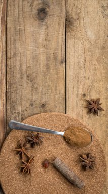 Ahşap bir masada baharatlar. Fotokopi alanı olan baharatlar. Çay kaşığındaki Hint baharatları. Tarçın tozu ve anis yıldızları ahşap bir masada fotokopi alanı ile. Yatay yönelim baharatları