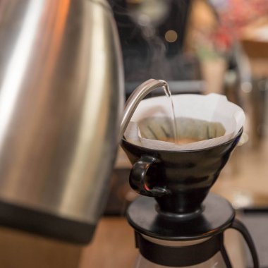 Barista kahve dükkanında filtre kahve yapıyor. 