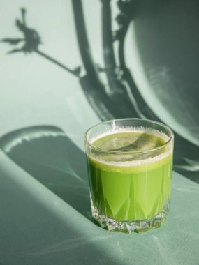 Kereviz suyu konsepti. Bardakta kereviz suyu ve arka planda kereviz gölgesi..   