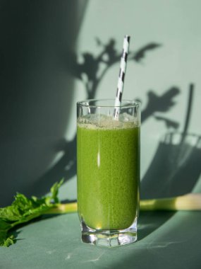 Kereviz suyu konsepti. Bardakta kereviz suyu ve arka planda kereviz gölgesi..   