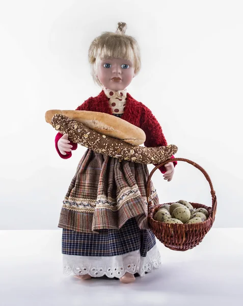 Páscoa menina-boneca com pão e cesta cheia de ovos — Fotografia de Stock