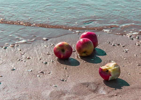 Beach with four apples
