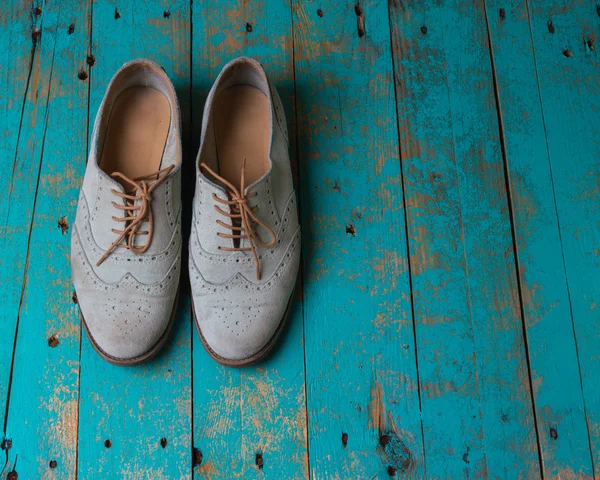 Female pair of suede light shade shoes on the wooded background — Stock Photo, Image