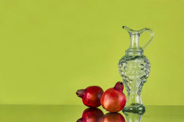 Still life with Pomegranates and glass Jug — Stock Photo, Image