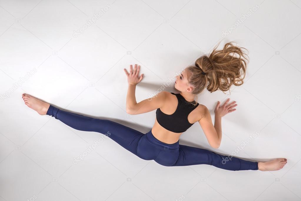 Rhythmic gymnast doing exercise in studio.