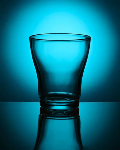 Empty glass beaker on blue background. Abstraction