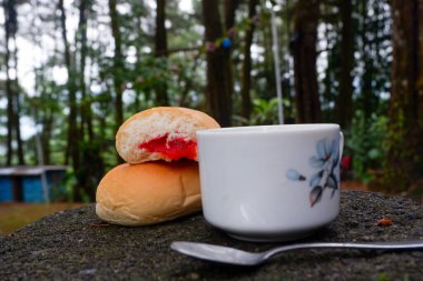 Bir fincan çayla çilek reçelli ekmek fotoğrafı. Ormandaki bir fotoğrafta
