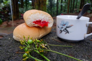 Bir fincan çayla çilek reçelli ekmek fotoğrafı. Ormandaki bir fotoğrafta