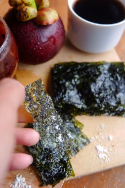 Doğranmış deniz yosununun, bir fincan kahvenin ve mangosonlunun fotoğrafı. İçkinin anlamını gösteren bir fotoğraf.