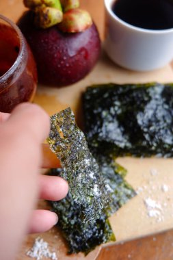 Doğranmış deniz yosununun, bir fincan kahvenin ve mangosonlunun fotoğrafı. İçkinin anlamını gösteren bir fotoğraf.