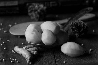 Fotoğraf, eski bir radyonun arka planında patates, zerdeçal ve beyaz biber şeklinde mutfak baharatları.
