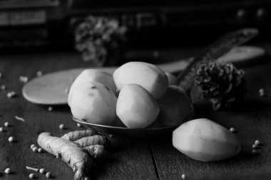 Fotoğraf, eski bir radyonun arka planında patates, zerdeçal ve beyaz biber şeklinde mutfak baharatları.