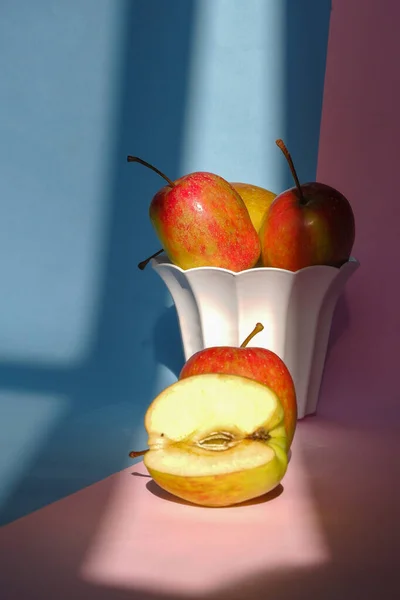粉红蓝色背景的容器中苹果的照片 — 图库照片