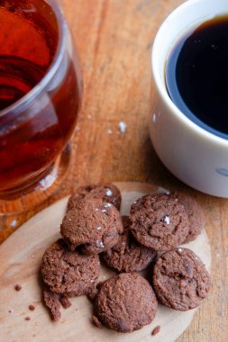 Bir pasta fotoğrafı ve iki bardak da ahşap bir masada içki.
