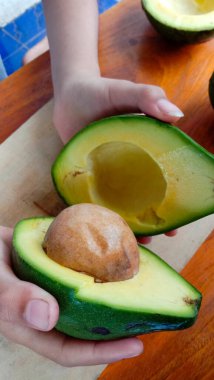 A photo of an avocado that has been split on a table