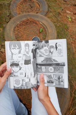 Photo of an Asian woman reading a comic book in Indonesian