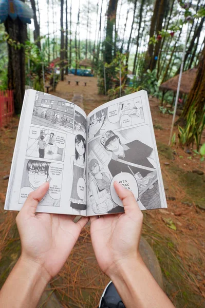 Zdjęcie Azjatki Czytającej Komiks Indonezyjsku — Zdjęcie stockowe