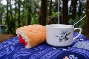 Bir fincan çayla çilek reçelli ekmek fotoğrafı. Ormandaki bir fotoğrafta