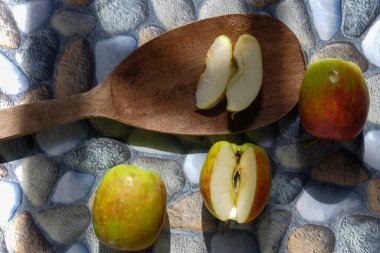 Çeşitli şekillerde elmaların fotoğrafları, bazıları hala sağlam, bazılarının arka planı taştan kesilmiş.