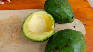 Avokado fotoğrafı ahşap bir masa ile bölünmüş.