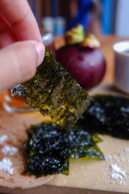 Doğranmış deniz yosununun, bir fincan kahvenin ve mangosonlunun fotoğrafı. İçkinin anlamını gösteren bir fotoğraf.