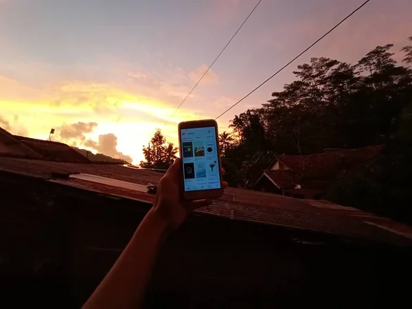 Foto Van Persoon Met Smartphone Met Zonsondergang Achtergrond — Stockfoto