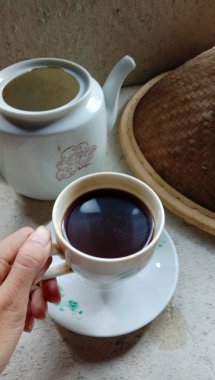 Bir fincan kahve ve geleneksel temalı bir kupa fotoğrafı, seramik bir temel malzeme kullanarak.