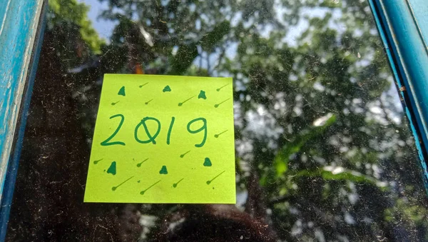 2019家の窓ガラスの背景に緑の紙とテキスト写真 — ストック写真