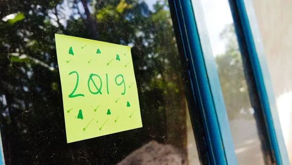 2019家の窓ガラスの背景に緑の紙とテキスト写真 — ストック写真