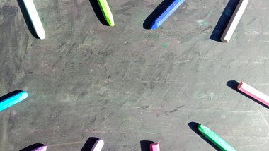 Yanında siyah arkaplan üzerine kitap olan renkli boya kalemi fotoğrafı.