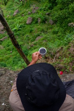 July 13, 2020, a man sits on a hill with a beautiful view, Wadaslintang, Indonesia