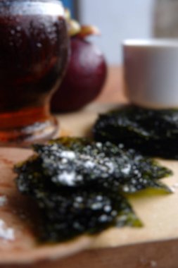 Ahşap arka planda hafif deniz yosunu ve kahvenin bulanık fotoğrafı