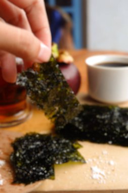 Ahşap arka planda hafif deniz yosunu ve kahvenin bulanık fotoğrafı