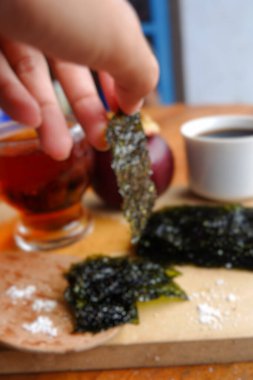 Ahşap arka planda hafif deniz yosunu ve kahvenin bulanık fotoğrafı