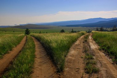 Güzel, sıcak bir yaz manzarası. İki yol farklı yönlere ayrılıyor. İzlerden biri Baykal Gölü kıyısına çıkıyor. Diğer yol tepelere çıkıyor. Güneş doğmamış bir tarlada parlıyor..
