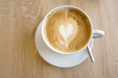 Kapuçino ahşap bir masa üzerinde bir cuo.