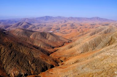 Alışılmadık bir kırmızı-turuncu renkli dağların üzerinde göster.