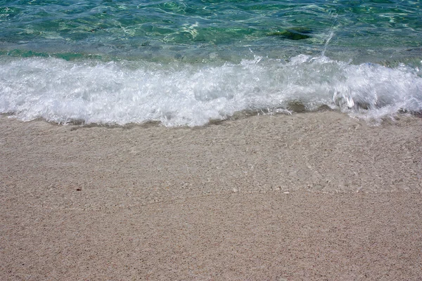 Une vague de cristal se déplaçant sur la plage d'Is Arutas . — Photo