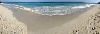 Denizde dalgalar olan kumlu sahil 