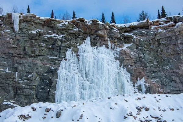 icicles on the rocks in the snow, winter waterfall