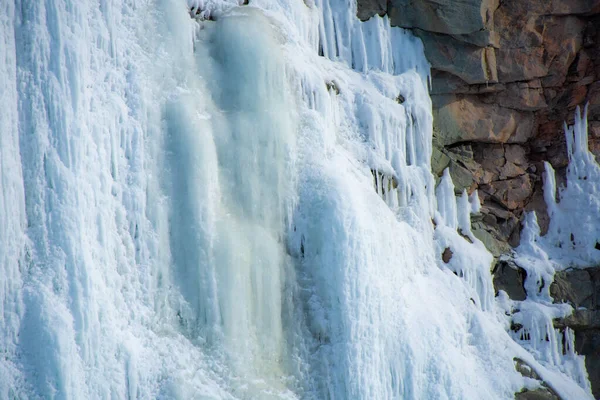 icicles on the rocks in the snow, winter waterfall