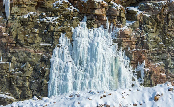 icicles on the rocks in the snow, winter waterfall