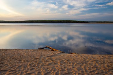 Gün batımında sığ bir gölün yüzeyinde güzel bir manzara.  