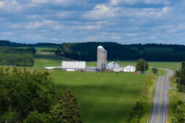 Yeşil sahnedeki yüksek yol ve çiftlik binaları manzarası