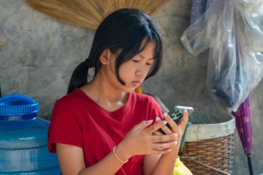 Köyde akıllı telefon kullanan genç bir kız.