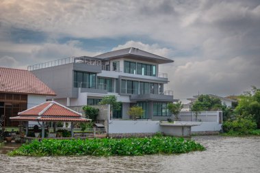 Nehir kenarında bulutlu gökyüzü olan modern bir ev