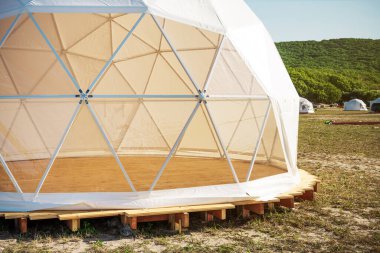 Jeodezik panoramik pencereli beyaz ev. Sahada dinlenmek için modern bir çadır kuruyorum. Modern bir çadırda turizm rahat.