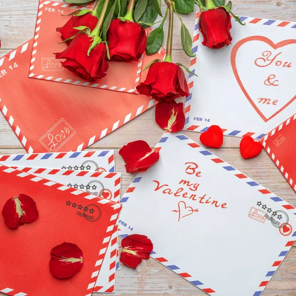 Red roses in bouquets. Letters, mail, vintage wooden background. The inscriptions 